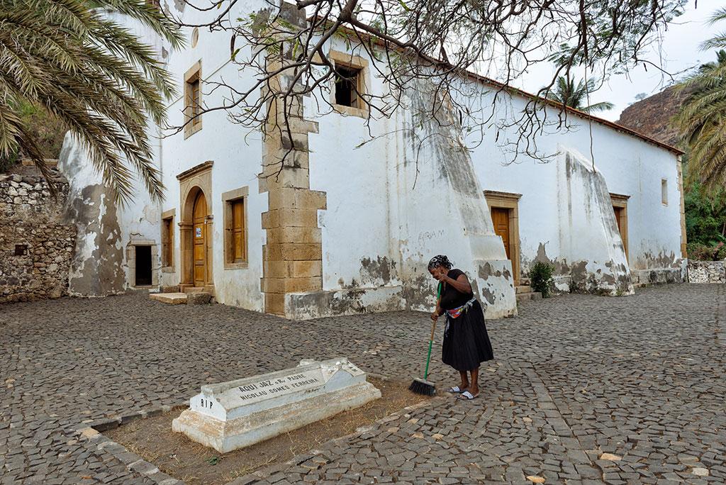 Mujer barriendo el exterior de la Iglesia Nuestra Señora del Rosario de Cidade Velha
