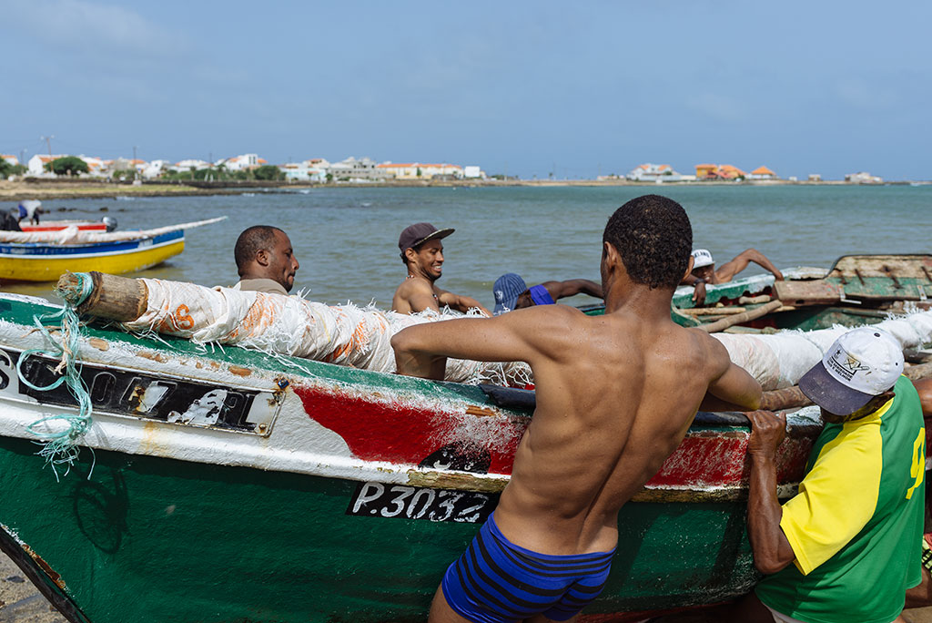 Hombres sacando barcas del mar