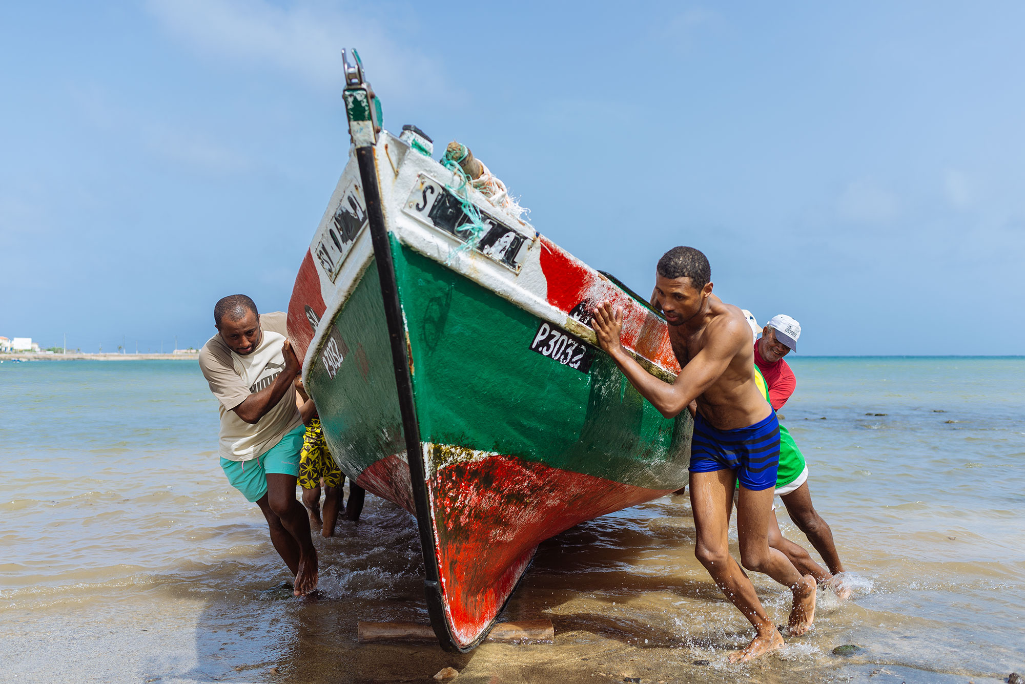 Hombres sacando barca de pescadores en Bahía das Gatas