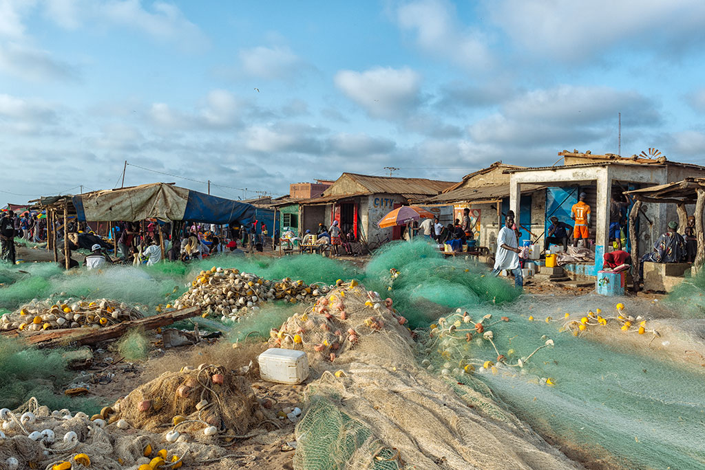 Las redes se extienden ante las casetas en la playa de Tanji, Gambia