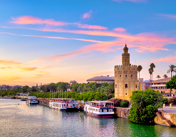 Torre del Oro de Sevilla junto al río Guadalquivir al atardecer.