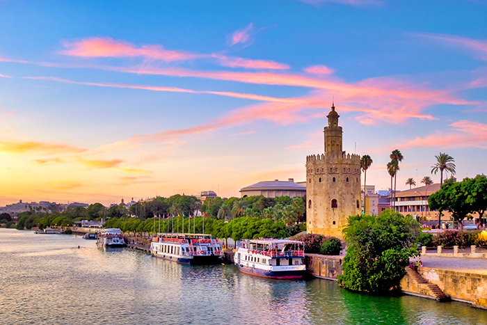 Torre del Oro de Sevilla junto al río Guadalquivir al atardecer.